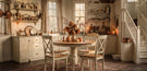 Practical Magic cosy autumn home styling blog banner shows round rustic wood table with matching wooden chairs in bright kitchen with white corner stair case