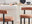 tips for choosing the perfect bar stool - image features 2 modern styling bar chairs with teracotta orange fabric, barrel style round back cushion, round seta, and black round legs in modern kitchen