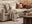 cream 4 seat left hand corner sofa in modern cosy living room with round coffee table and side table