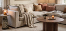 cream 4 seat left hand corner sofa in modern cosy living room with round coffee table and side table