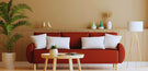 interior design trends blog header shows orange sofa in Scandi inspired room with round coffee table and pot plant