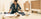 the history of flatpack furniture blog header image shows a woman building a flat pack sideboard