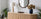 oak wood sideboard with ribbed fluted paneling, and walnut wood wiggly framed wall mirror for mixed wood styling guide