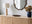 oak wood sideboard with ribbed fluted paneling, and walnut wood wiggly framed wall mirror for mixed wood styling guide