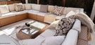 rattan garden sofa under pergola with comfy pillows and blankets to create an outdoor living space