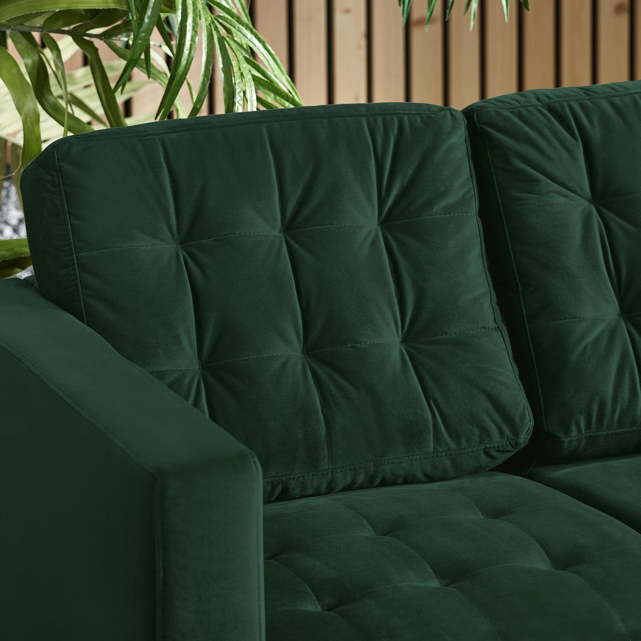 close up detail of green velvet sofa with button tufted back