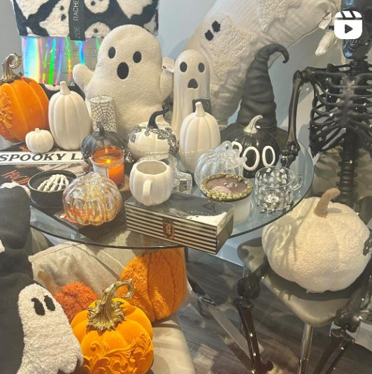 Halloween decor ideas for your home featuring halloween themed accessories on a round glass dining table with chrome legs