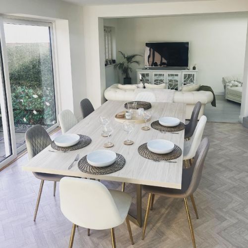 how to decorate white walls - white open plan livng room dining space with pale wood table and faux leather chairs