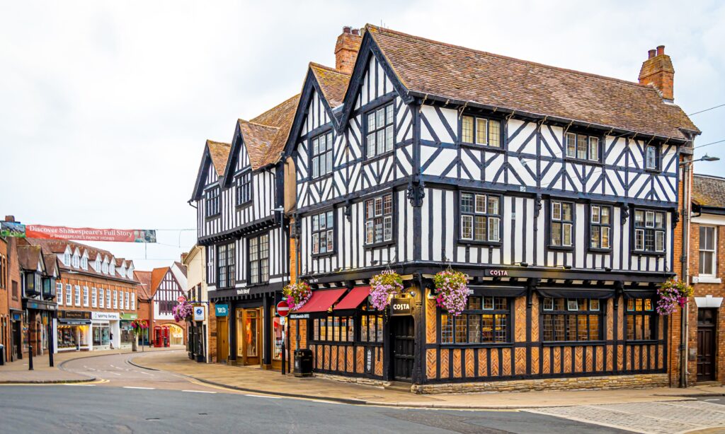 Stratford upon Avon voted number 1 happiest place in the UK - image shows Tudor black and white building in high street setting, home to highs treet shops