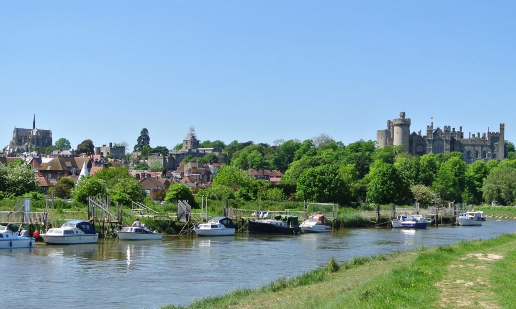 Arundel, West Sussex, voted 4th most stylish place to live in the UK - river Arun with boats, and town with castle and catherdral beyond