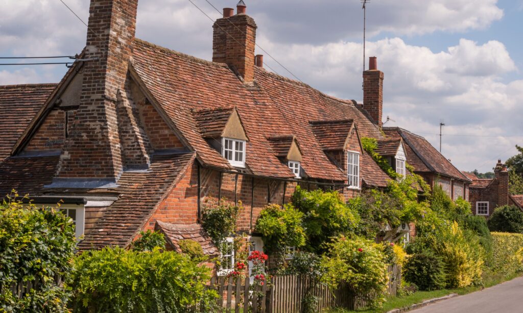 Turville, Buckinhamshire, voted 5th most stylish place to live in the UK - image shows pretty red brick cottages with blue sky and clouds