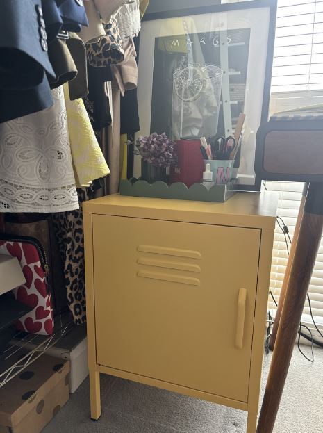 bedroom makeover on a small budget - yellow metal locker style bedisde table used as bedroom office storage, with desk tidy tray on top, framed art and clothes rail wardrobe beside it